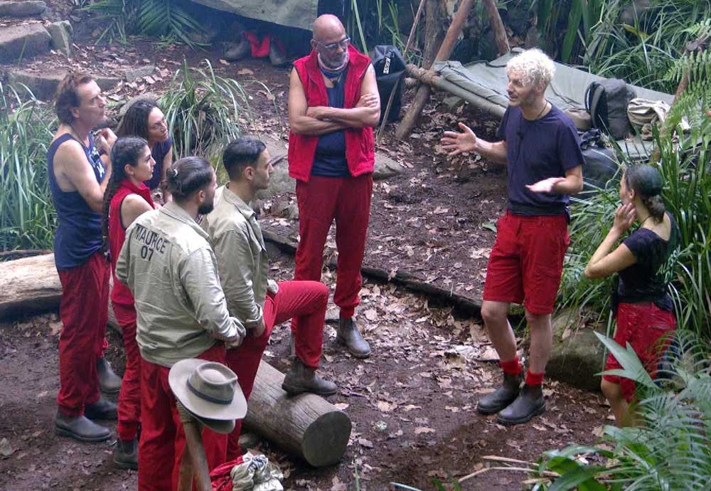 ibes_2025 Sam Dylan (2.v.r.), Alessia Herren (r.), erklären sich vor den anderen Campbewohner/ Foto: RTL